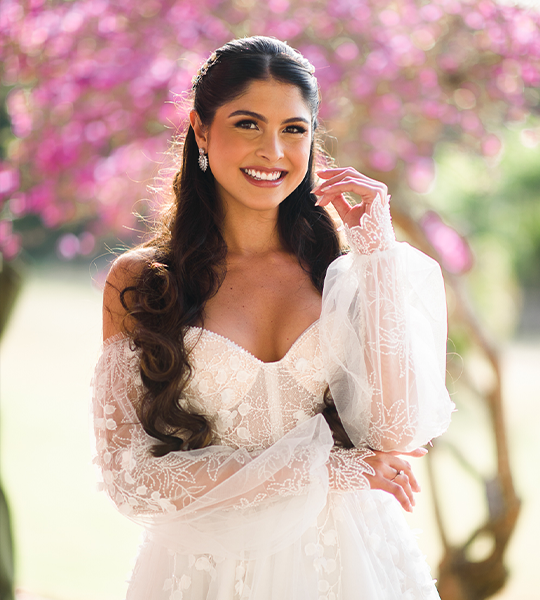 Noiva sorrindo com penteado de ondas e maquiagem luminosa