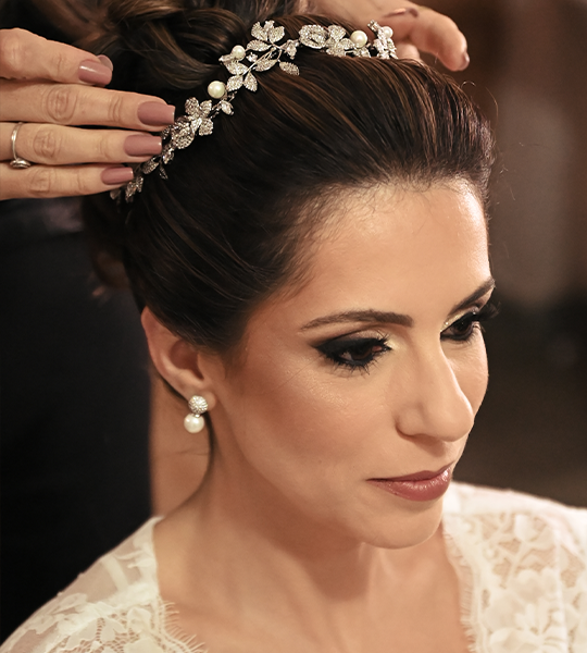 Tiara de pérolas sendo colocada no coque da noiva
