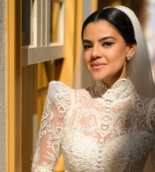 Noiva com véu e penteado preso em vestido de renda